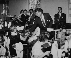 President John F. Kennedy shaking hands witha union worker in a factory